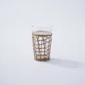 Closeup view of handcrafted woven rattan sleeve on clear glass cup, showing detailed texture. - Style 4