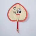 Hand-woven straw fan detail showing the heart shape, red fabric trim, and cute panda design. - Style 7