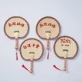 Handmade woven straw fan detail shot showcasing traditional Chinese cooling fan design and red tassels. - Style 32