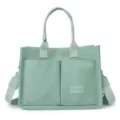 Light green canvas tote bag with double front pockets, top handles and shoulder strap. - L34 H25 T14 / Green