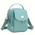 Vue détaillée du sac bandoulière en tissu oxford vert menthe avec plusieurs compartiments zippés. - Vert malachite