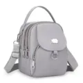 Détail du mini sac à dos gris en tissu Oxford avec multiples poches zippées pratiques. - Gris clair