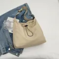 Minimalistische einfarbige Nylon Umhängetasche mit Kordelzug und praktischen Taschen. - Gebrochenes Weiß