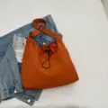 Casual orange nylon bucket bag with drawstring design and adjustable shoulder strap for daily use. - Orange