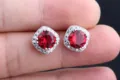 Rote Edelstein Ohrstecker Nahaufnahme, glänzender Zirkon Halo, exquisite Schmuck Detail Ansicht. - Rot