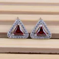 Primo piano dettagliato di orecchini geometrici in zircone, eleganti perle rosse e bianche. - Rosso