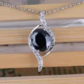 Detailansicht der eleganten S-förmigen Zirkonia-Halskette mit einem schwarzen Mittelstein. - Mit Kette / Schwarz