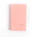 Detailed closeup of a cute pink solid color card holder and business card organizer album. - Pink