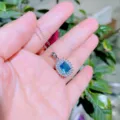 Silberfarbene Halskette mit einem rechteckigen blauen Kristallanhänger und funkelndem Zirkonia-Halo. - Halskette / Seeblaue Zirkonia Halskette