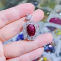 Nahaufnahme eines atemberaubenden ovalen roten Zirkonanhängers mit funkelndem weißem Zirkon. - Fuchsia