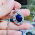 Nahaufnahme Detail des blauen Zirkon Ovals Anhänger mit funkelndem weißen Zirkonia Kranz. - Saphirblau