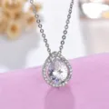 Detailed close-up of a stunning pear-cut cubic zirconia halo pendant necklace sparkling. - Necklace / White