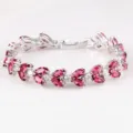 Detaillierte Nahaufnahme des exquisiten rosa Zirkon Blatt Tennis Armband in Weißgold Optik. - Rot
