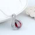 Nahaufnahme des roten Zirkon-Anhängers im Tropfenschliff, filigrane Silberkette mit Glanz. - Titanstahl Kette / Granatrot