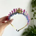 Close-up detail of the crystal crown headband featuring colorful crystals and a gold bee. - Red Blue With Gold Bee