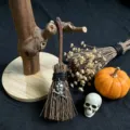 Miniature Halloween witch broom detail with skull pendant charm and rustic wooden stand. - Silver Skull Crossbones Style / 13*4cm