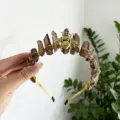 Detailed shot of the crystal raw stone and gold bee headband, showcasing exquisite handmade wire. - Smoky Quartz With Gold Bee
