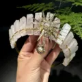 Close-up detail of handmade natural rose quartz crown headband with golden sun and pearl. - Rose Quartz + Gold Artificial Pearl Sun Goddess