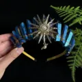 Vista dettagliata del cerchietto con corona di cristallo blu e accessorio dea del sole per donna. - Blu Scuro Oro Sole