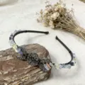 Detailed shot of handmade crystal chip headband with metal crescent moon symbols for festival wear. - Fluorite