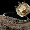 Close-up detail of the handmade crystal moon gemstone headband with vintage metal charms on bark. - Mixed Stones With Moon