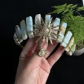 Detail view of natural crystal crown headband featuring sun goddess charm and wire. - Amazon