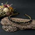 Handgefertigtes Detail mit schwarzen Kristallperlen, elegantes Design auf rustikaler Rinde. - Obsidian & Schwarz