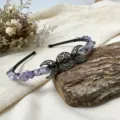 Detail view of handmade crystal headband featuring a metal triple moon charm and purple crystal chips. - Amethyst