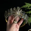 Detailed shot of the crystal tiara showcasing the intricate sun goddess metalwork and pearls. - Labradorite