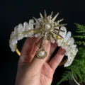 Hand holding crystal crown headband featuring sun goddess charm and raw quartz crystals. - AB White Gold Sun