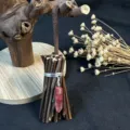 Close-up of a handmade witch broom ornament with pink crystal and dry flowers. - 10*3.5CM / Red Cracked Stone