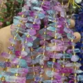 Primo piano perle cristallo irregolari colorate, componenti fai-da-te in fluorite con dettagli oro. - Vivace (N)
