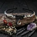 Detailed close up of crystal chip headband with metal pentagram and crescent moon charm on wood. - Sunstone+Black Star Moon+Champagne Drop