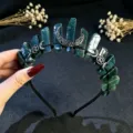 Primer plano del tiara de cristal verde natural con dijes de luna y estrella plateados. - Ágata Musgosa Y Luna Negra