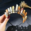 Detalle de la tiara de cristales en bruto con alfileres negros y colgante decorativo de luna gótica. - Aventurina Roja Y Luna Negra