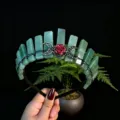 Detailed close-up of the green crystal tiara headband featuring a red rose and crescent moons. - Green Aventurine + Black Moon + Flower