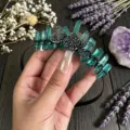 Close-up detail of the green crystal crown headband featuring a black moon metal charm. - Black Wire Triple Moon (Black Triple Moon Headband) / Green