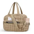 Quilted travel tote bag with puffy design, dual top handles, shoulder strap, and side pockets. - Camel