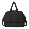 Gros plan détaillé du sac de voyage matelassé noir avec compartiment inférieur et poignées. - Noir