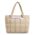 Close-up detail of the beige quilted puffy tote bag, showing soft texture and front pocket. - 17.7 x 5.9 x 12.6 Inches / Camel