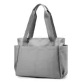Grey nylon tote bag front pocket detail and durable handle close up view for travel. - Gray