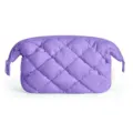 Close-up of a purple quilted puffy cosmetic bag detail showing soft texture and zipper. - Purple