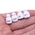Vue détaillée de mini pots d'épices en bois pour maison de poupée, avec de minuscules étiquettes. - Condiments pack de 4