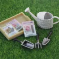 Miniature dollhouse garden tool set detail showing tiny watering can and seed packets. - Flower Seeds Set / Beige