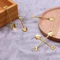 Close-up van mini metalen scheplepels, gouden DIY-legeringsaccessoires voor decoratief gebruik. - Goud