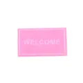 Miniature pink non-woven dollhouse doormat detail with welcome text and white border. - Pink