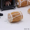 Detailed close-up view of miniature straw bale dollhouse prop, tiny hay bundle accessory. - Straw