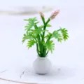 Vue détaillée d'une mini plante en pot de maison de poupée avec feuilles vertes et fleurs. - Rose