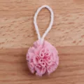 Detailed close-up view of a miniature pink dollhouse bath puff model with a hanging string. - Pink
