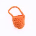 Dettaglio di mini borsa in lana lavorata all'uncinetto, accessorio carino per casa delle bambole. - Arancione